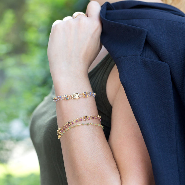 Earth Song Jewelry model showing gold multistrand beaded stone bracelets