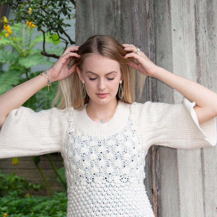 Earth Song Jewelry model wearing gold moonstone and turquoise jewelry set
