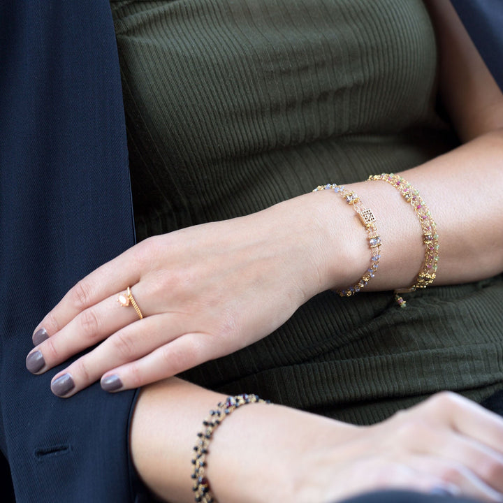 Earth Song Jewelry model wearing gold multistrand beaded stone bracelets