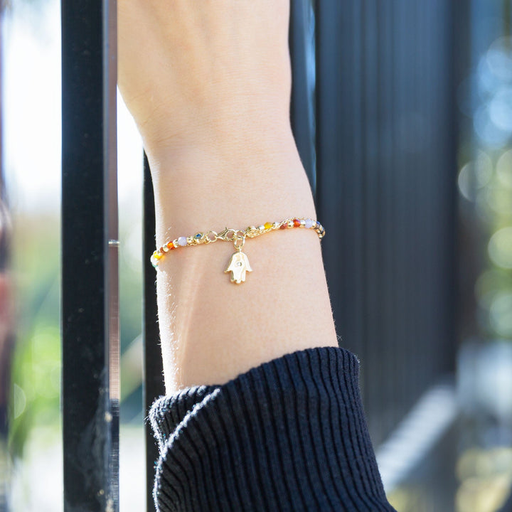 Earth Song Jewelry model wearing gold sterling silver Chakra stone hamsa charm bracelet