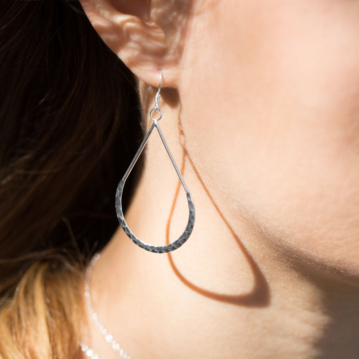 Earth Song Jewelry model wearing hammered sterling silver pear shaped earrings