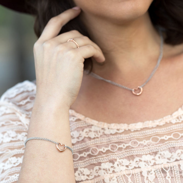 Earth Song Jewelry model wearing sterling silver rose gold heart bracelet and necklace