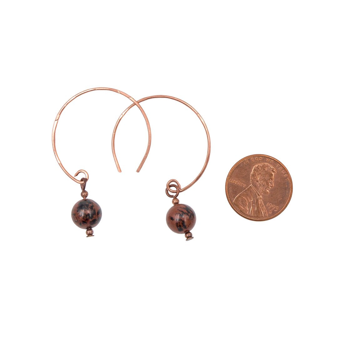 Earth Song Jewelry handmade Mahogany Obsidian Hoop Curves Copper earrings. Next to a coin for sizing context.